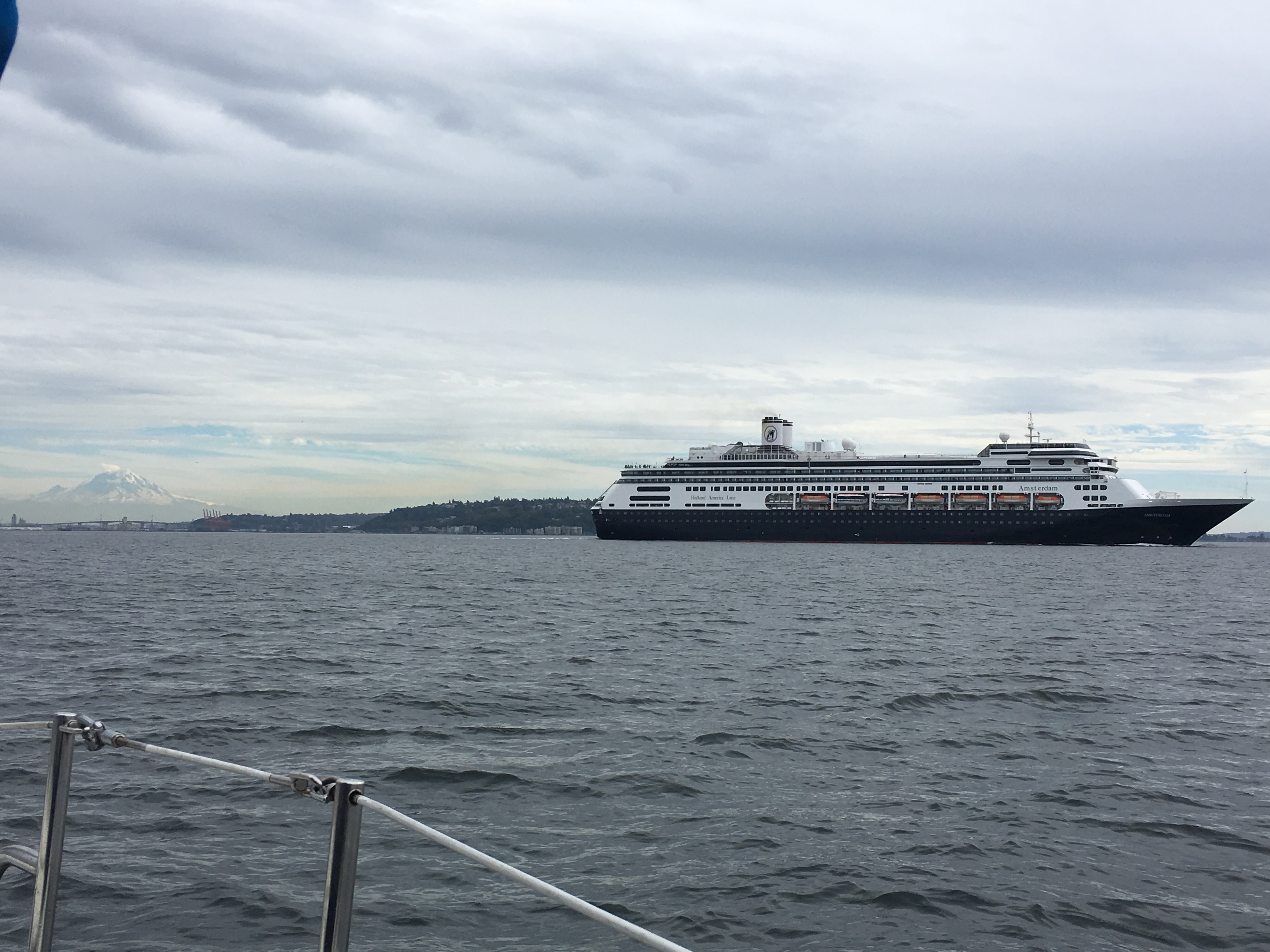 Cruise ship passing the Seattle waterfront under a cloudy sky.