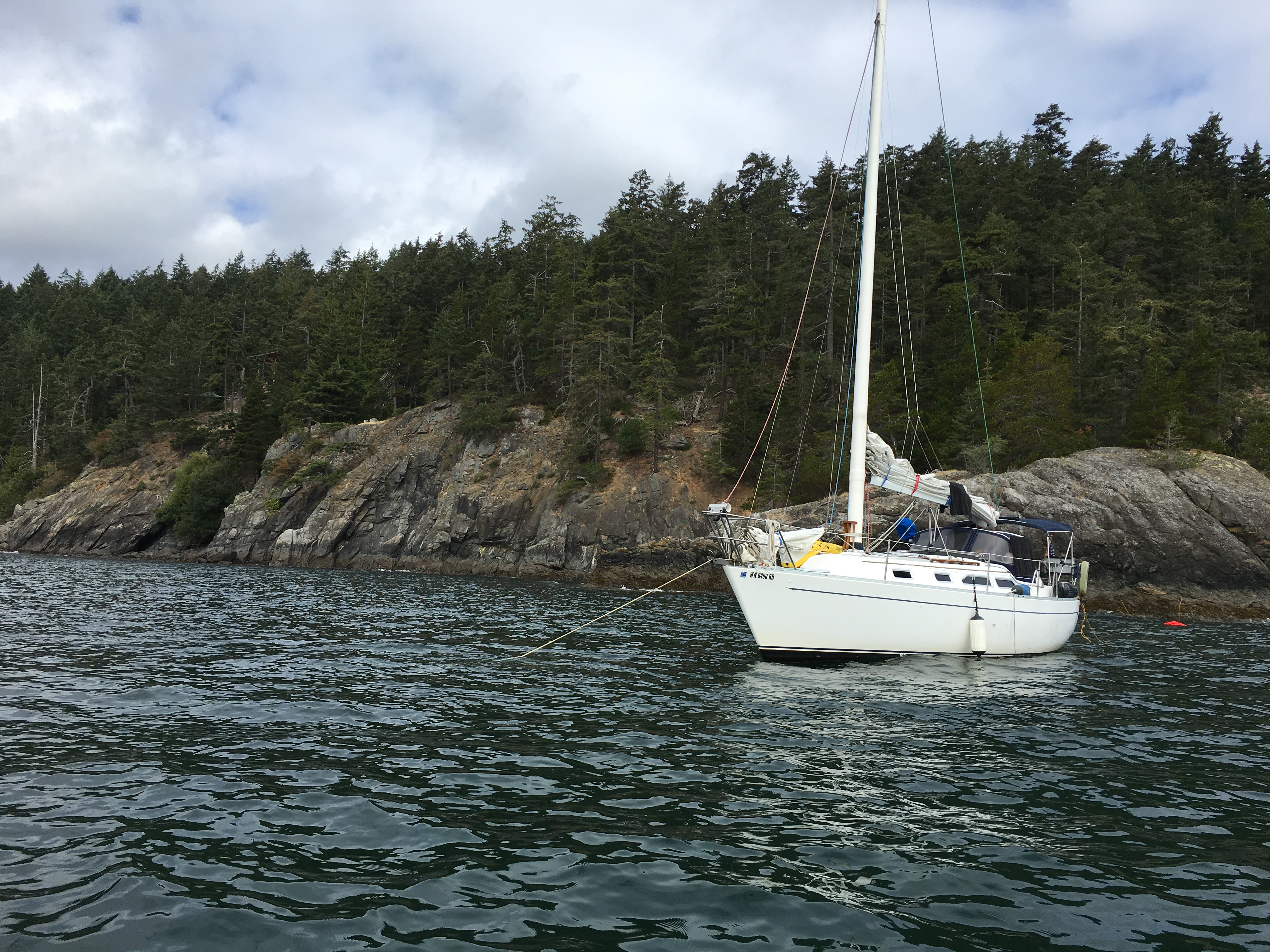 Zephyr anchored beside a rocky shoreline in the San Juan Islands.