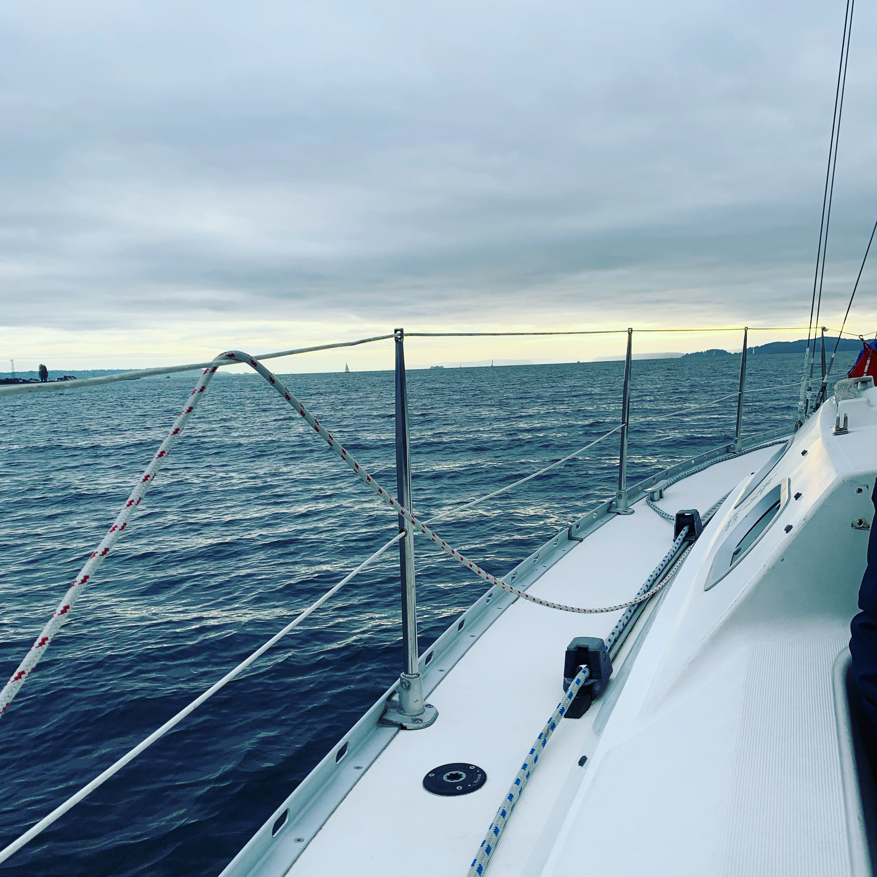 Guests relaxing aboard a charter sail with calm water stretching ahead.