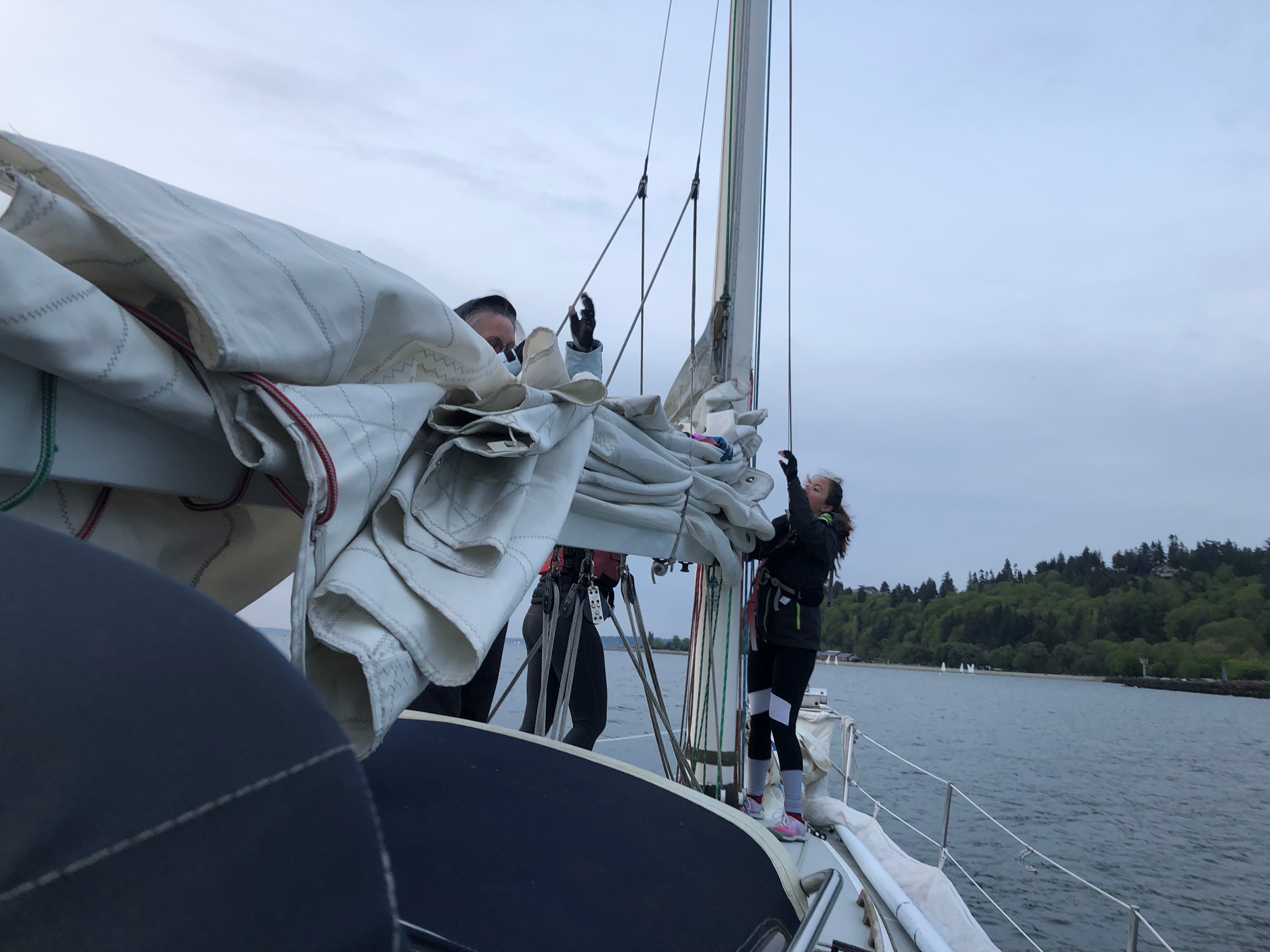 Students working sails during a hands-on lesson on the water.