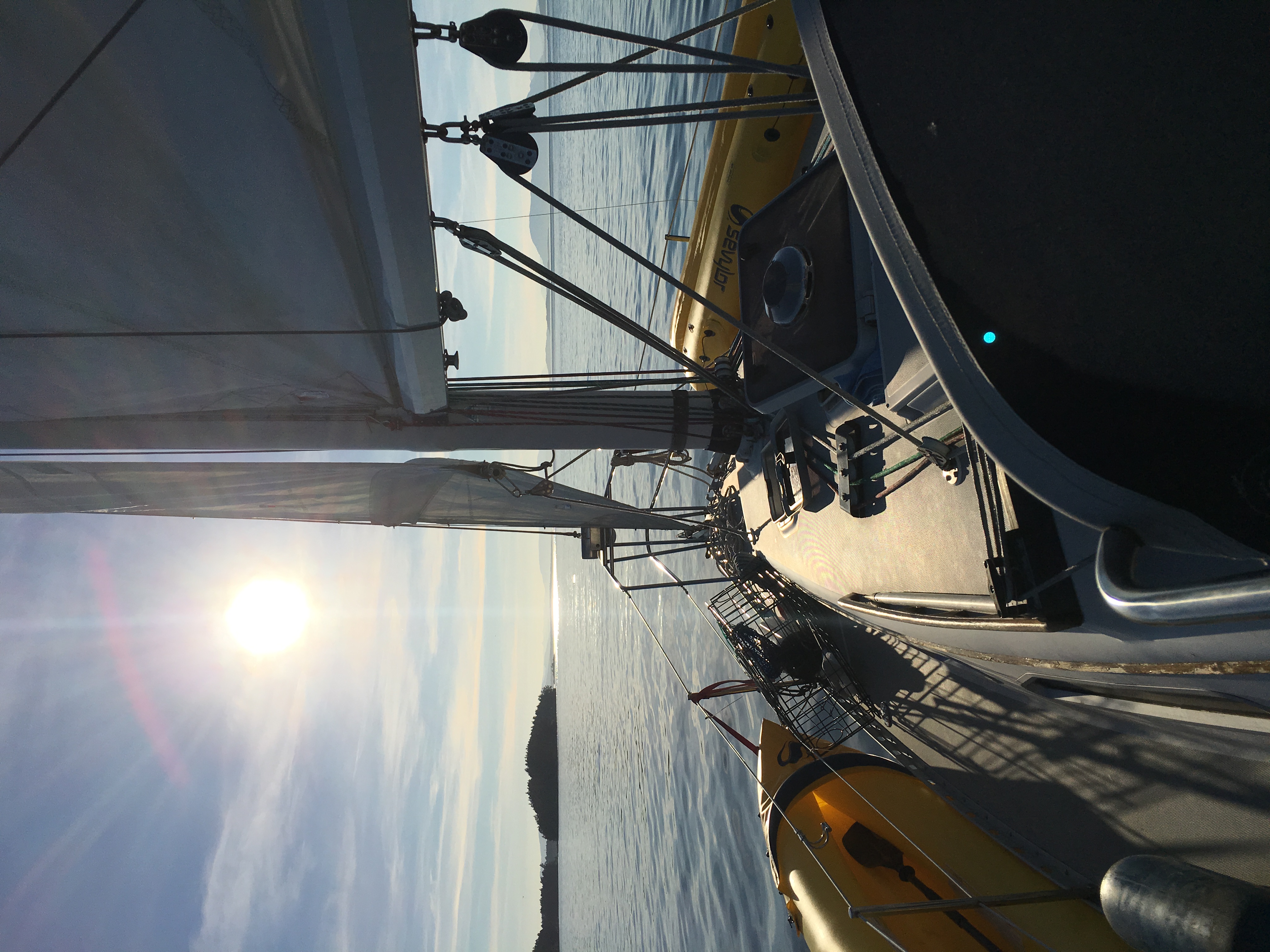 Sunlit sails and open water during a sunset cruise.